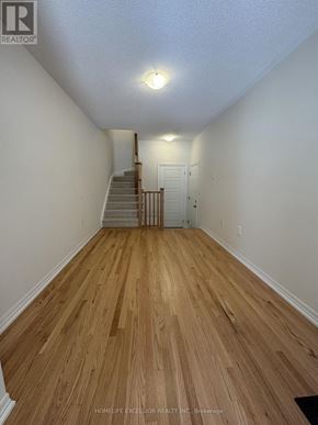 Newmarket (Woodland Hill) townhouse for rent - A hallway with wooden floors and a staircase.