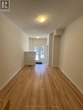Newmarket (Woodland Hill) townhouse for rent - A long hallway with wooden floors and white walls.