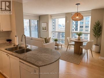 Toronto (Bay Street Corridor) condo for rent - A kitchen with a sink and a dining table with chairs.