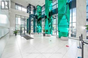 Toronto (Waterfront Communities) condo for rent - The interior of a building with a glass wall and a green abstract sculpture.