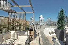Toronto (Waterfront Communities) condo for rent - A patio with a white couch and a tree in a pot.