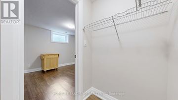 East Gwillimbury (Sharon) apartment for rent - A room with a wooden floor and a white wall with a small window.