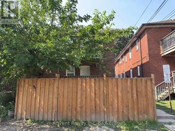 Toronto (Lawrence Park South) duplex for rent - A wooden fence in front of a red brick building.