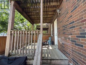 Toronto (Lawrence Park South) duplex for rent - A wooden deck with a brick wall and a doorway.
