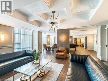 Hamilton condo for rent - A modern living room with a glass coffee table and a large window.