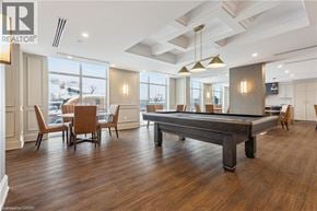 Hamilton condo for rent - A pool table in a room with wooden floors and a high ceiling.