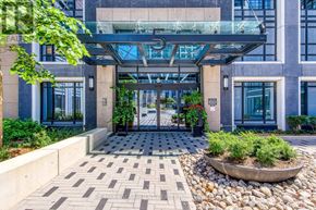 Toronto (Islington-City Centre West) condo for rent - A modern building entrance with a glass canopy and a stone planter in the foreground.