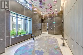 Toronto (Islington-City Centre West) condo for rent - A hallway with a carpet and a glass elevator.