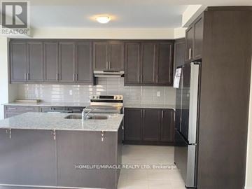 Brampton (Northwest Brampton) townhouse for rent - A kitchen with dark brown cabinets and a granite countertop.