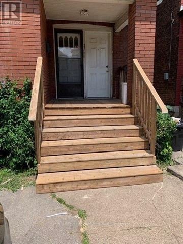 Hamilton (Stipley) triplex for rent - A set of wooden stairs leading to a white door.