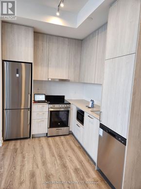Vaughan (Vaughan Corporate Centre) condo for rent - A modern kitchen with wooden cabinets and stainless steel appliances.