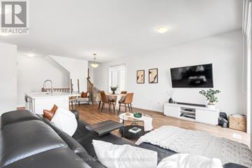 Ottawa townhouse for rent - A living room with a black couch and a television.