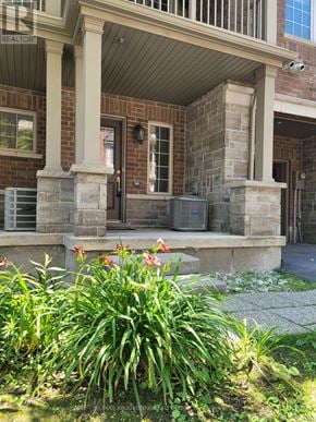 Burlington (Freeman) townhouse for rent - A house with a porch and a flower bed in front.