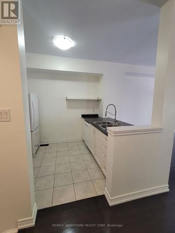 Burlington (Freeman) townhouse for rent - A kitchen with white cabinets and a black counter top.