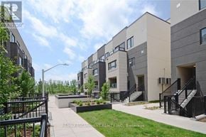 Burlington (Lasalle) townhouse for rent - A modern apartment complex with a landscaped courtyard in the foreground.