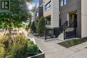 Burlington (Lasalle) townhouse for rent - A sunny day at a modern apartment complex with a well-maintained garden.