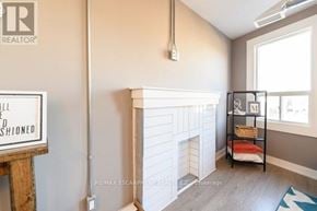Hamilton (Stipley) townhouse for rent - A room with a fireplace and a shelf with books and a cushion.