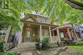 Toronto (The Beaches) apartment for rent - A house with a front porch and a front yard with a small tree.