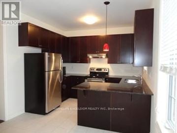 Markham (Wismer) apartment for rent - A kitchen with a stainless steel refrigerator and a black counter top.