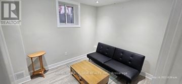 Markham (Wismer) apartment for rent - A living room with a black couch and wooden side table.