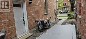 Markham (Wismer) apartment for rent - A bicycle is parked on a concrete path in front of a brick house.