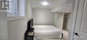 Markham (Wismer) apartment for rent - A bedroom with a bed, a television, and a door.