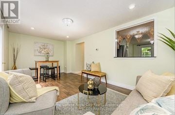 Guelph (Willow West/Sugarbush/West Acres) townhouse for rent - A living room with a grey couch, a coffee table, and a dining table with chairs.