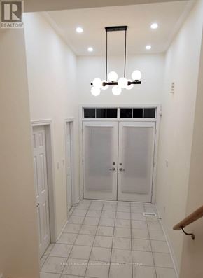 Brampton (Bram West) apartment for rent - A hallway with a chandelier and a door with frosted glass.