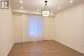 Brampton (Bram West) apartment for rent - A room with a hanging light fixture and a window with curtains.