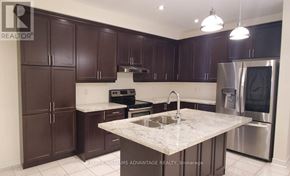 Brampton (Bram West) apartment for rent - A kitchen with dark brown cabinets and a marble countertop.