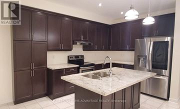 Brampton (Bram West) apartment for rent - A kitchen with dark brown cabinets and a marble countertop.