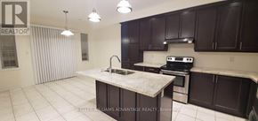 Brampton (Bram West) apartment for rent - A kitchen with dark brown cabinets and a granite counter top.