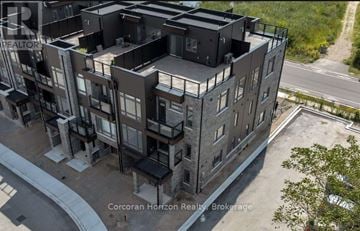 Orillia townhouse for rent - An aerial view of a multi-story building with balconies and a road in front.