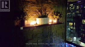 Toronto (Niagara) condo for rent - A wall with a stone pattern and a planter with plants and candles.