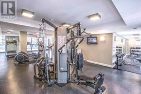 Toronto (Niagara) condo for rent - A gym with a variety of equipment including a treadmill, weights, and a television.