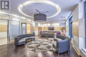 Toronto (Niagara) condo for rent - A modern living room with a circular light fixture and a large rug.