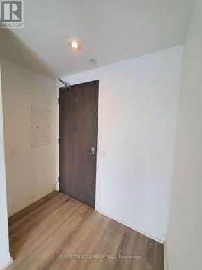 Toronto (Moss Park) condo for rent - A room with a wooden floor and a brown door.