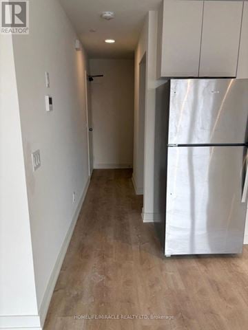 St. Catharines (E. Chester) townhouse for rent - A white refrigerator is in a kitchen with wood flooring.