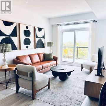 Collingwood condo for rent - A living room with a brown leather couch, a wooden armchair, a coffee table, and a television.