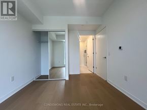 Toronto (Regent Park) condo for rent - A white interior of a room with wood flooring and a sliding door.