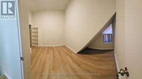 Toronto (University) apartment for rent - A room with a wooden floor and a staircase leading to another room.