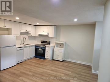 Toronto (University) apartment for rent - A kitchen with white cabinets and a white fridge.