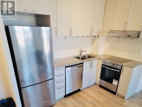 Markham (Unionville) condo for rent - A kitchen with a stainless steel refrigerator, a sink, and a stove top oven.
