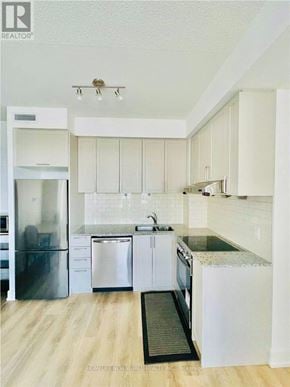 Markham (Unionville) condo for rent - A modern kitchen with white cabinets and stainless steel appliances.