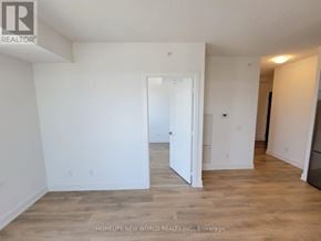 Markham (Unionville) condo for rent - A room with white walls and wooden flooring, with a doorway leading to another room.