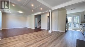 Richmond Hill (Crosby) apartment for rent - A spacious room with wooden flooring and a staircase leading to another room.