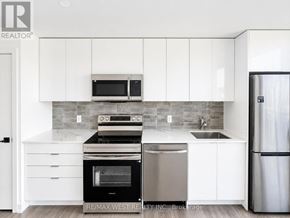 Brantford condo for rent - A modern kitchen with white cabinets and stainless steel appliances.