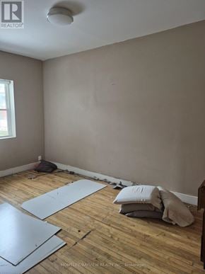 Toronto (Greenwood-Coxwell) apartment for rent - A room with wooden flooring and a window is being prepared for renovation.