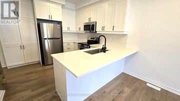 Markham (Victoria Square) townhouse for rent - A kitchen with white cabinets and a white island.