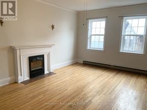 Stratford multi-family for rent - A room with a fireplace and two windows.